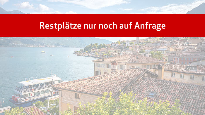 Restplätze nur noch auf Anfrage - Blick über Limone am Gardasee mit Ausflugsschiff und Strandpromenade